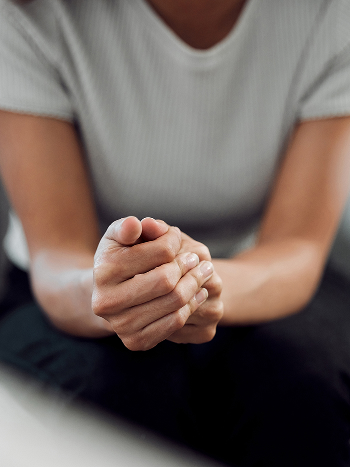 Hands, psychology and mental health with a woman in a therapy session for grief counseling after loss. Anxiety, stress or depression with a female patient feeling nervous in a clinic for support